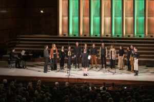 Das Foto zeigt einen Chor auf der Bühne der Rudolf-Oetker-Halle bei der Nacht der Chöre 2023.